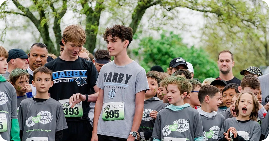 junior coach standing next to runners