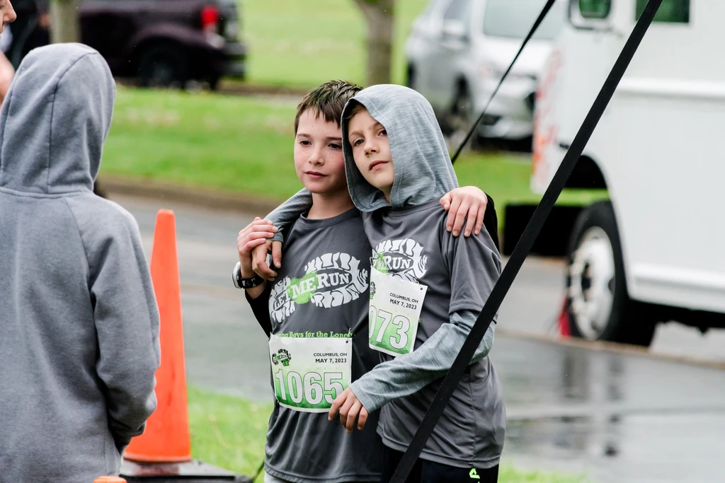 boys hugging one another after 5k race charlotte nc
