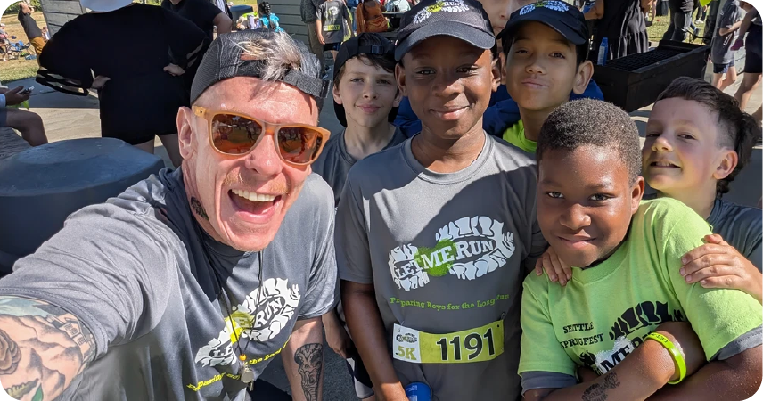head coach posing for photo with running group