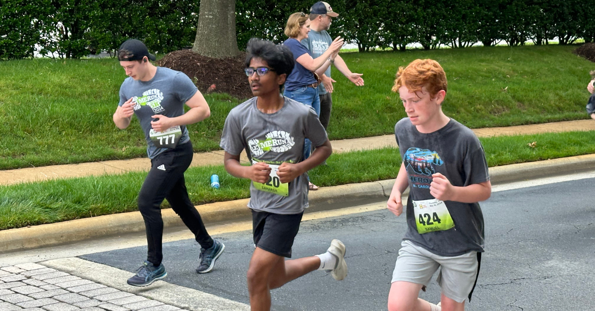 5k race day volunteer giving high five to runner