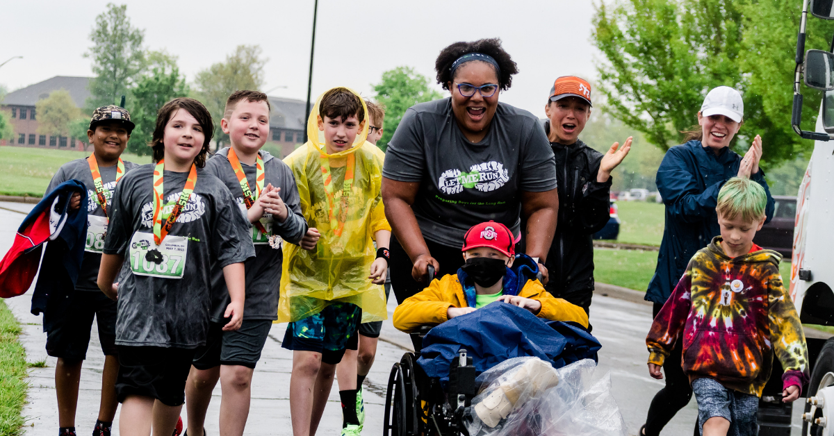 assistant coach waving to runners